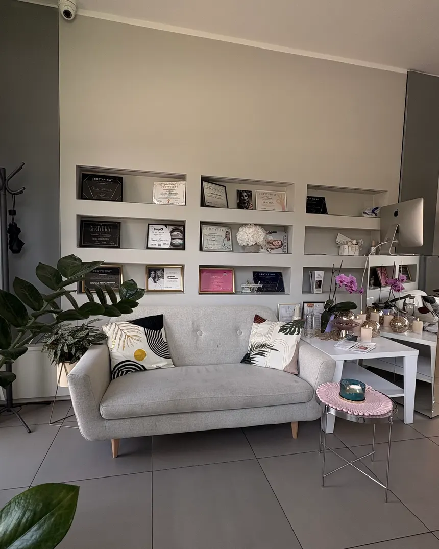 Poczekalnia BLISS — jasna sofa i ściana z certyfikatami